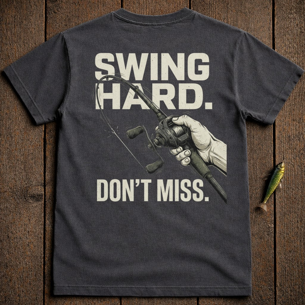 T-shirt with "Swing Hard. Don't Miss." and a fishing reel graphic.
