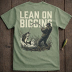 Fisherman reeling in a large bass, text "LEAN ON BIGGINS".