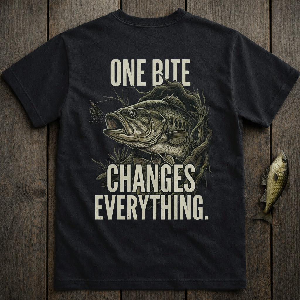 Dark t-shirt with a bass fish and fishing lure, text "ONE BITE CHANGES EVERYTHING".