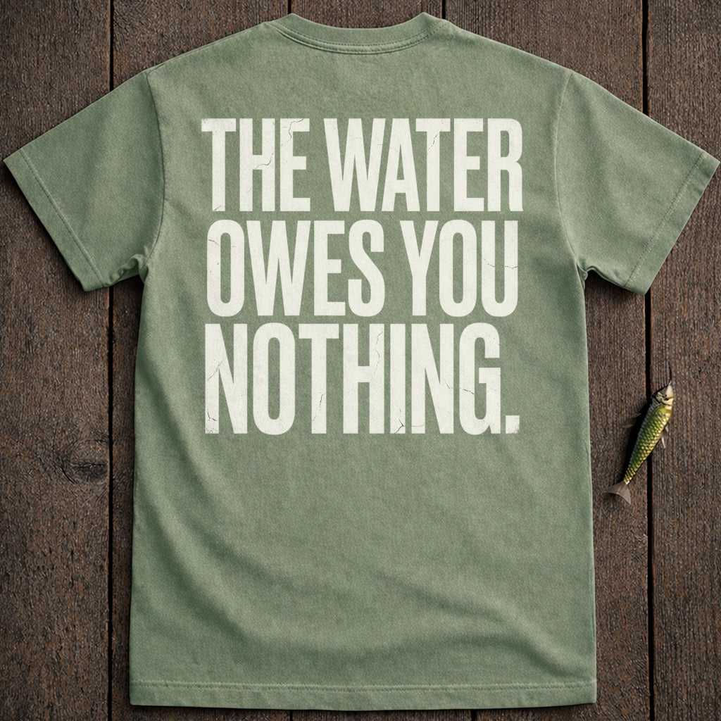 Green t-shirt with "THE WATER OWES YOU NOTHING" text, on wooden background.