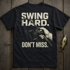 Black t-shirt with "SWING HARD. DON'T MISS." and a fishing rod illustration.