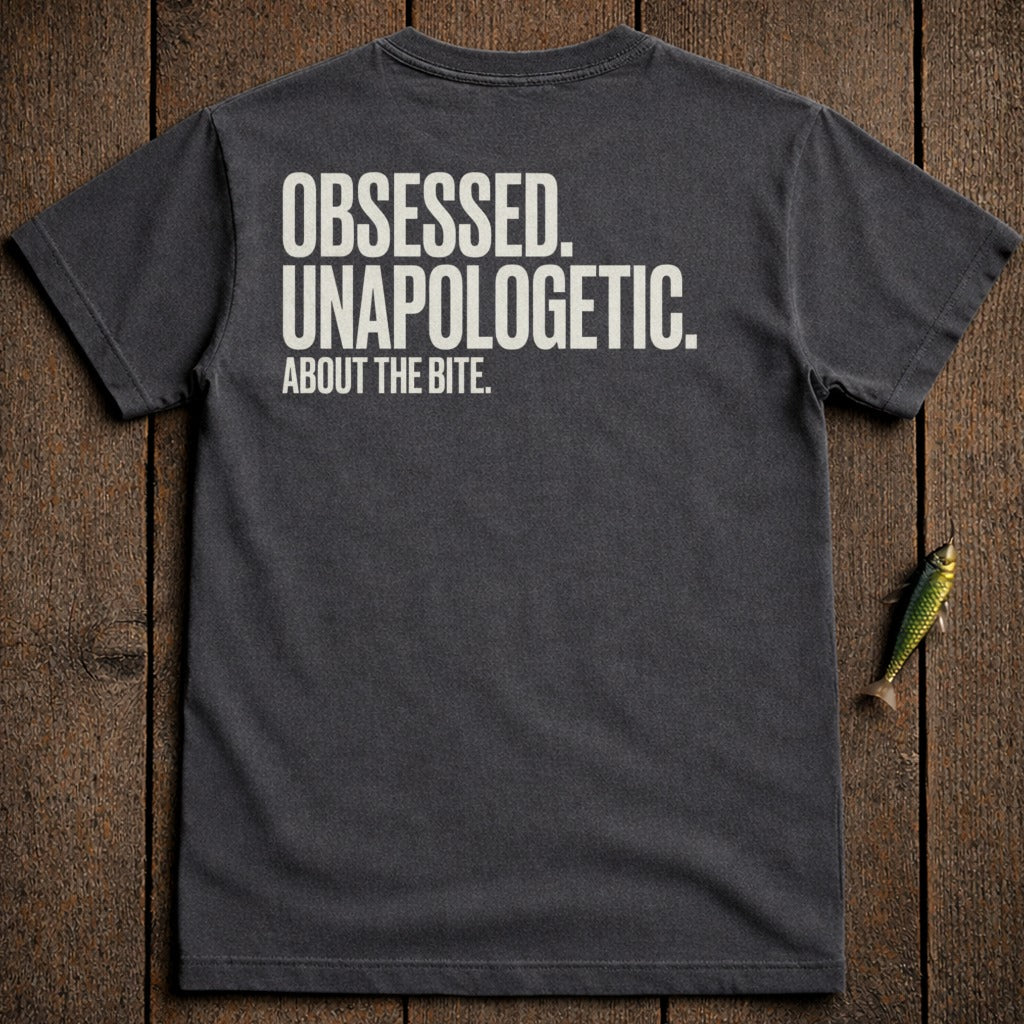 Dark grey t-shirt with white text "OBSESSED. UNAPOLOGETIC. ABOUT THE BITE."
