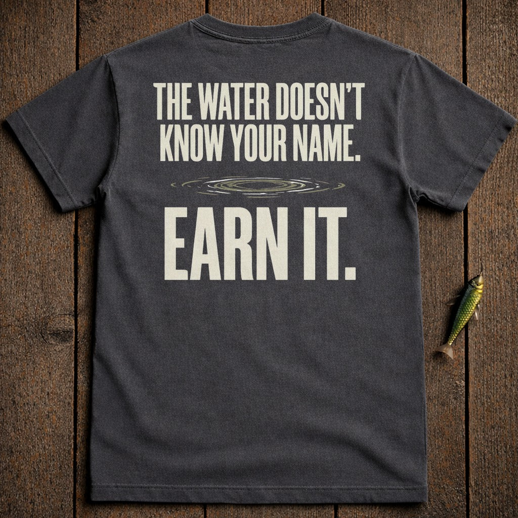 Dark t-shirt with "The water doesn't know your name. Earn it." text.