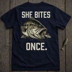 Navy t-shirt with a large bass eating a smaller fish and text "SHE BITES ONCE."