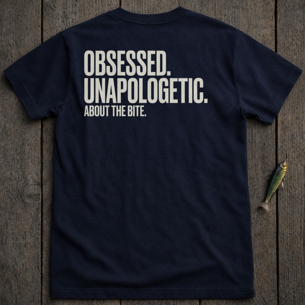 Navy t-shirt with white text "OBSESSED. UNAPOLOGETIC. ABOUT THE BITE."